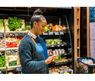 Supermarket Staff Using Tablet in Produce Section